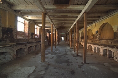 Inne i Östra stallet före ombyggnationerna, långt rum med pelare och spiltor längs väggarna