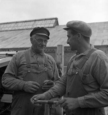 Två män som står och pratar på en fabrik
