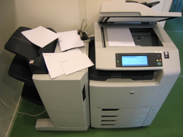 En skrivare/kopiator med papper på