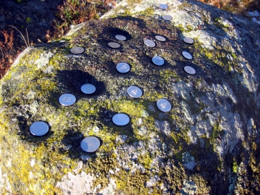 Skålgropsstenen i Akalla med ilagda mynt