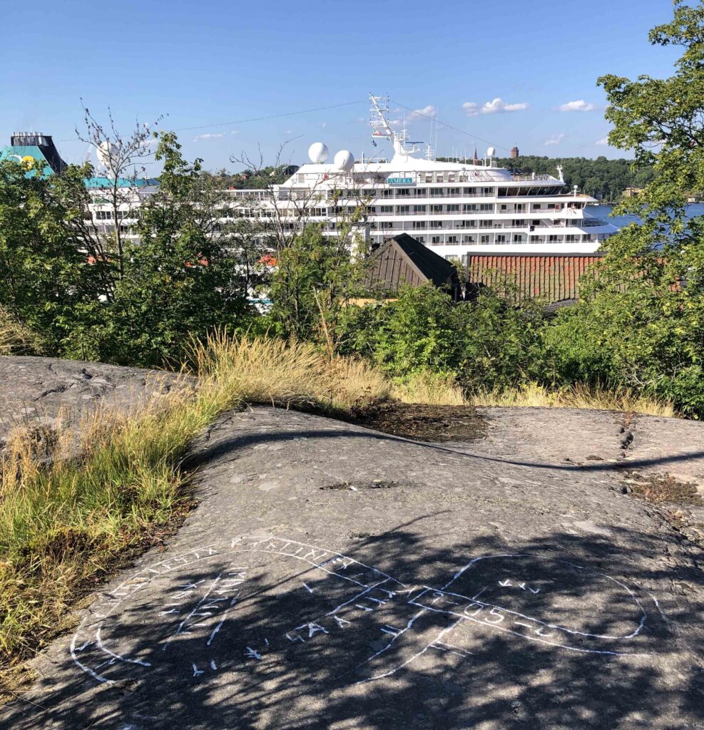 sentida runristning i fast häll med färja i bakgrunden
